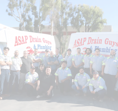 A group of people pose in front of two ASAP Drain Guys & Plumbing trucks in a parking lot, ready to tackle any plumbing repair or general plumbing needs.